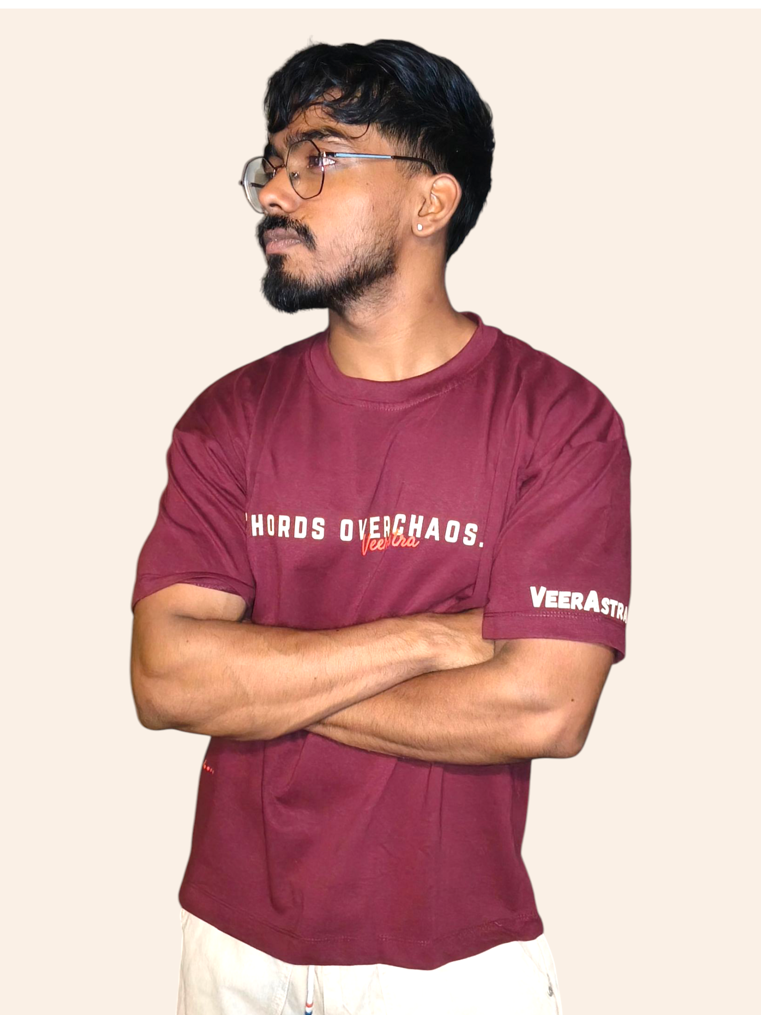 Man wearing a VeerAstra maroon t-shirt with text on a beige background