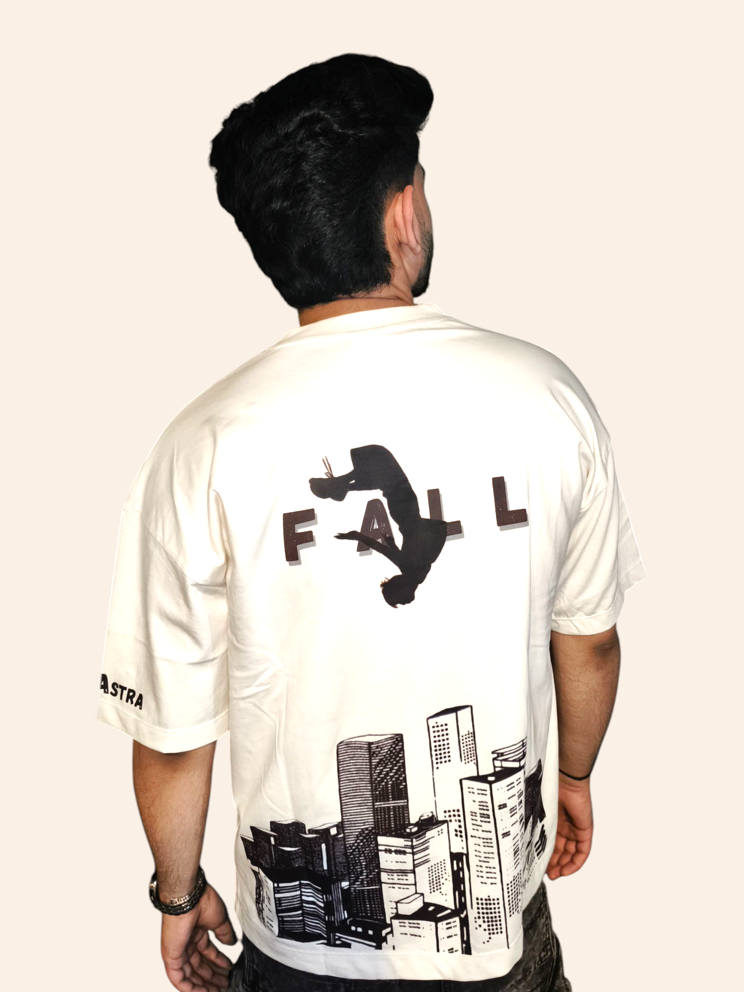 Person wearing a white VeerAstra t-shirt with black graphics and text on the back, standing against a plain background.
