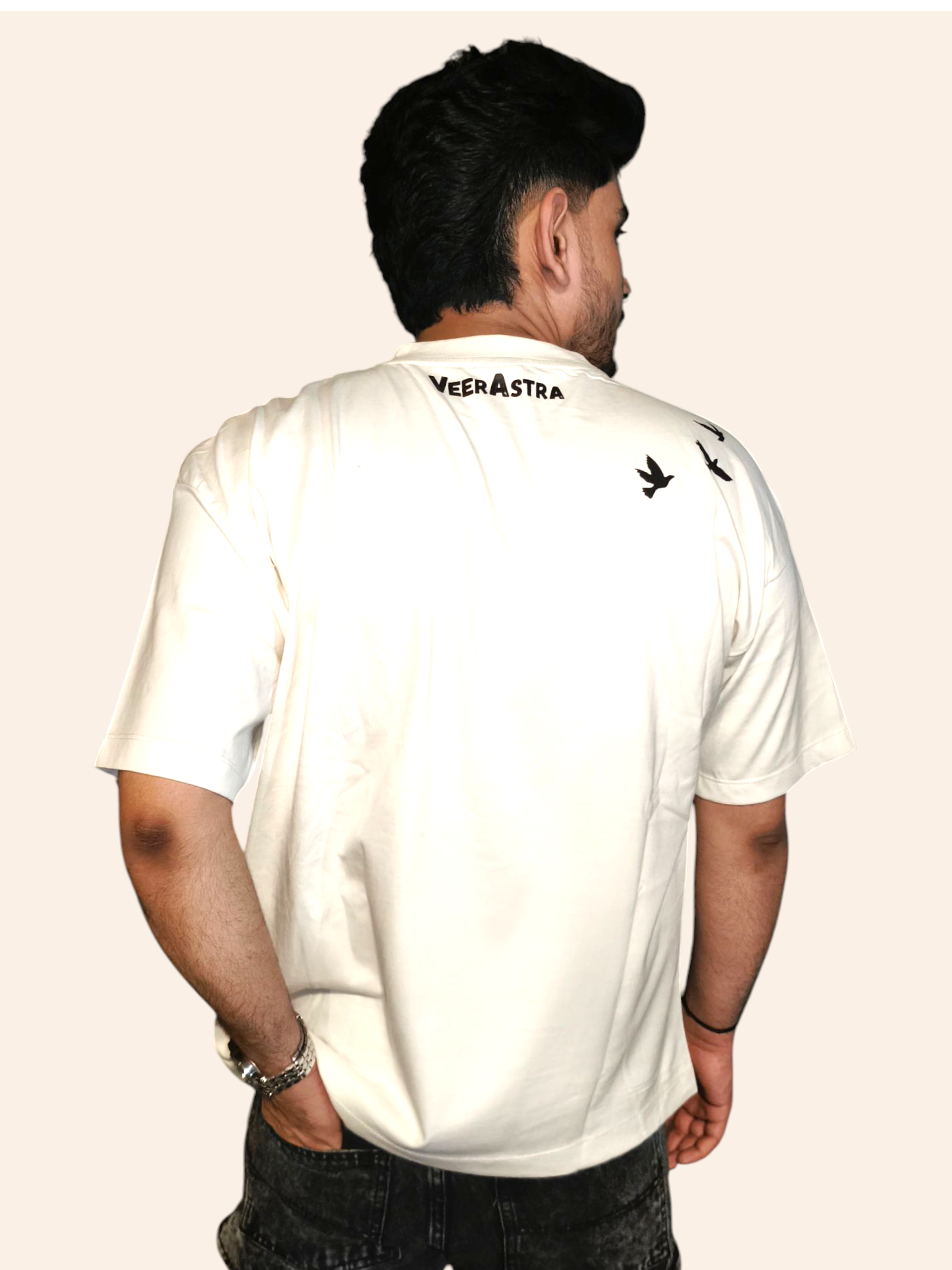 Person wearing a VeerAstra white t-shirt with branding on the back against a plain background