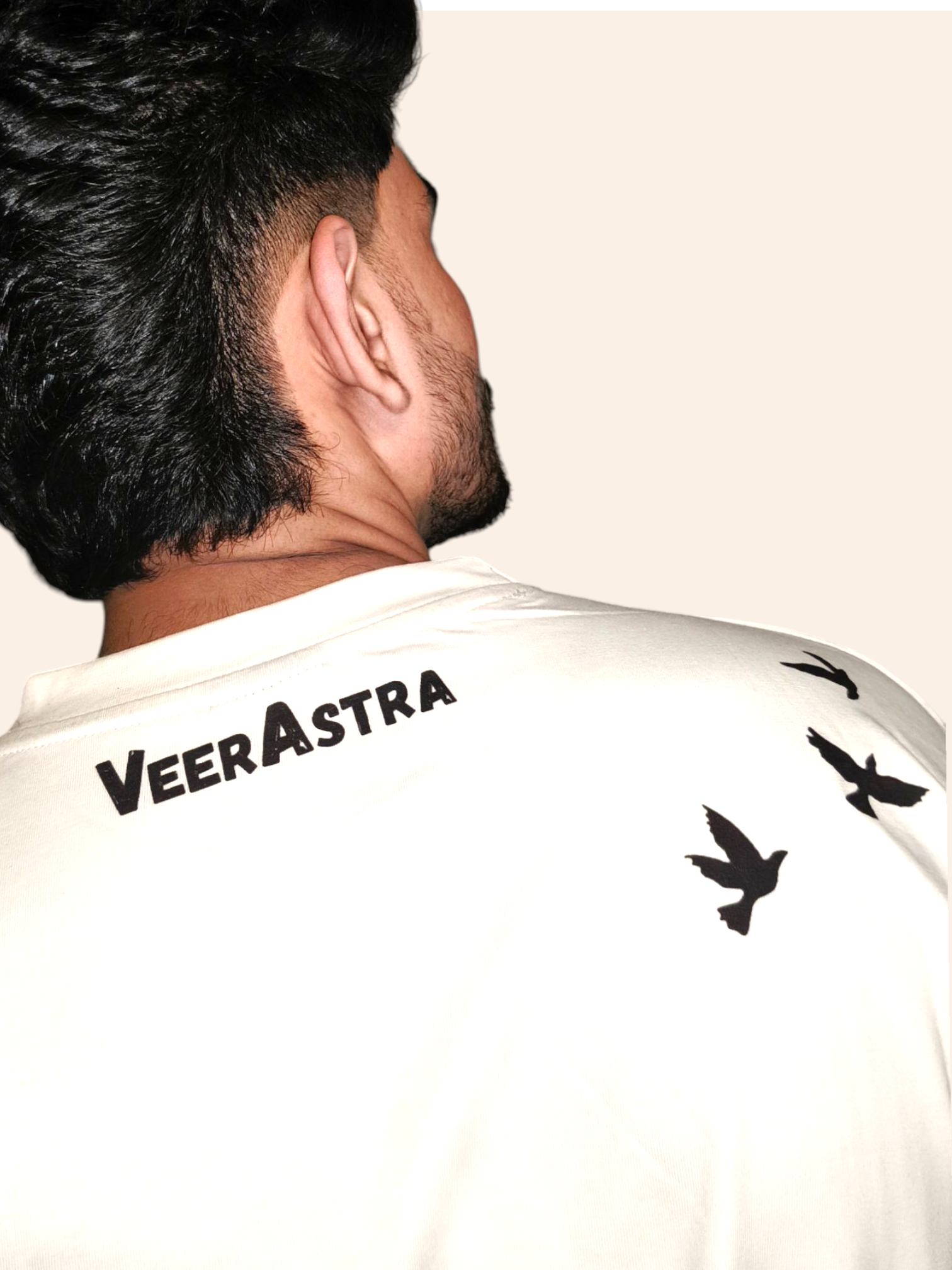 Person wearing a VeerAstra white shirt with 'VeerAstra' branding and black bird graphics.