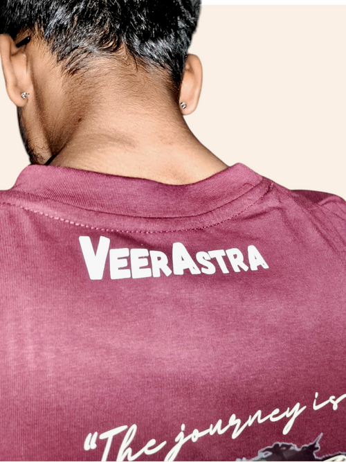 Person wearing a maroon shirt with 'VEERASTRA' branding on the back.