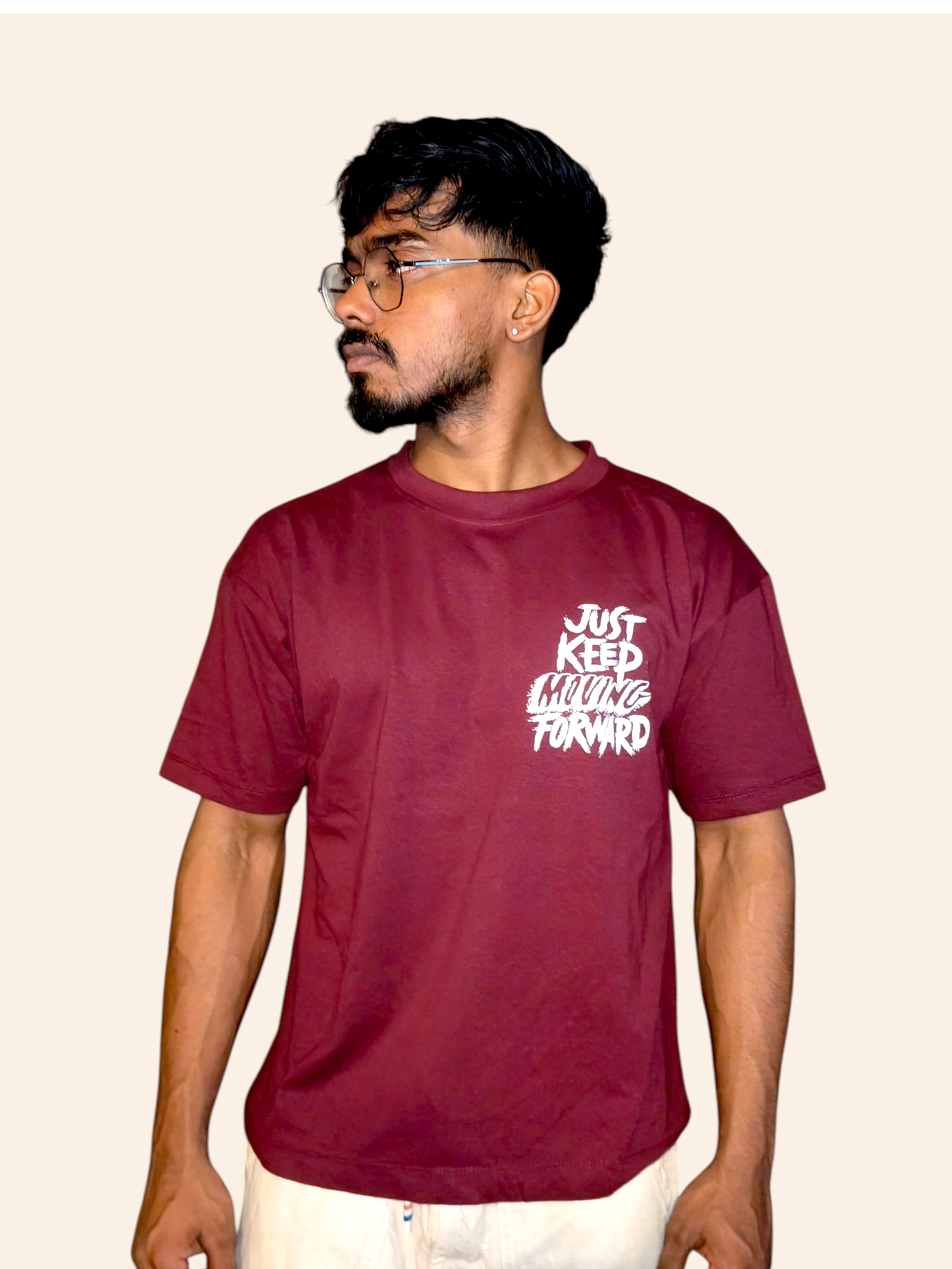 Person wearing a VeerAstra maroon t-shirt with white text on a beige background