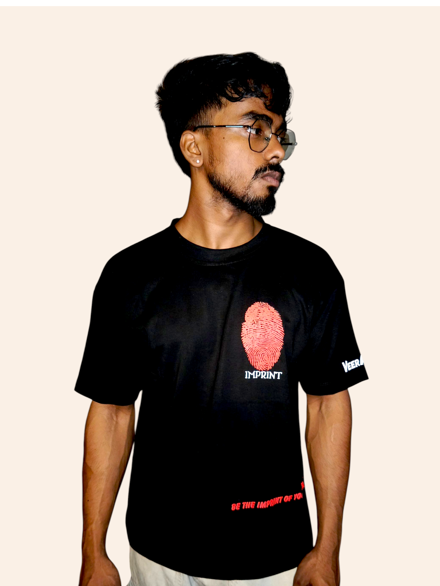 Person wearing a black VeerAstra t-shirt with a graphic design on a beige background