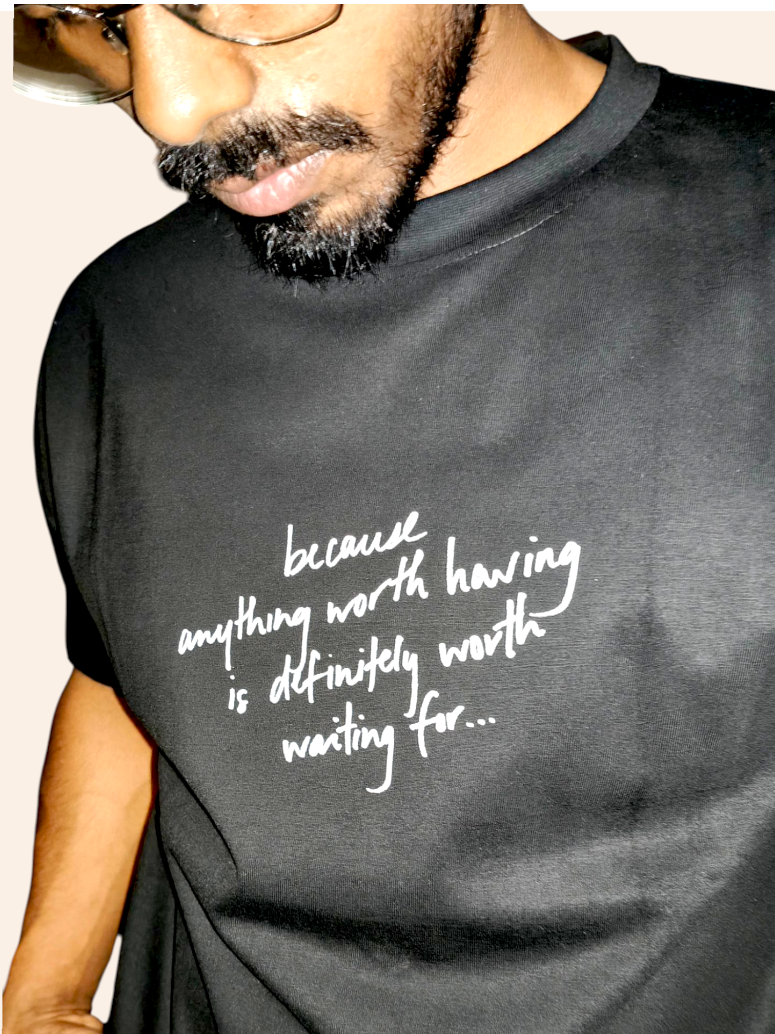 Person wearing a black classic VeerAstra t-shirt with white text on a plain background