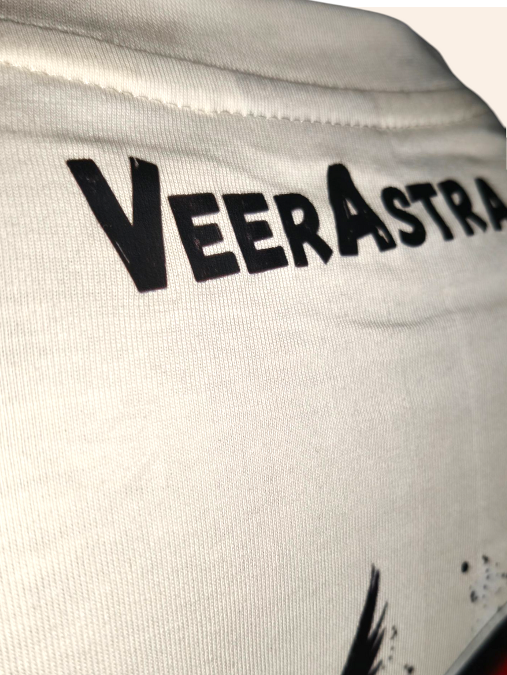 Close-up of a white garment with 'VeerAstra' branding.