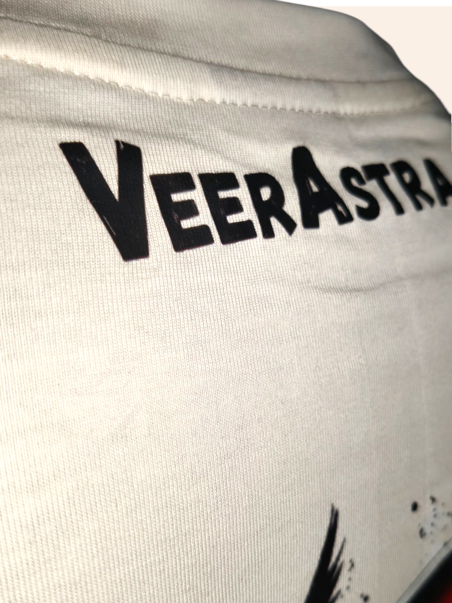 Close-up of a white garment with 'VeerAstra' branding.