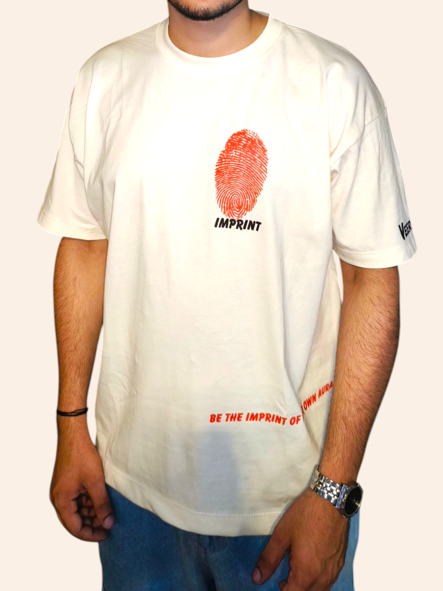 Person wearing a white VeerAstra t-shirt with a red fingerprint design and text.