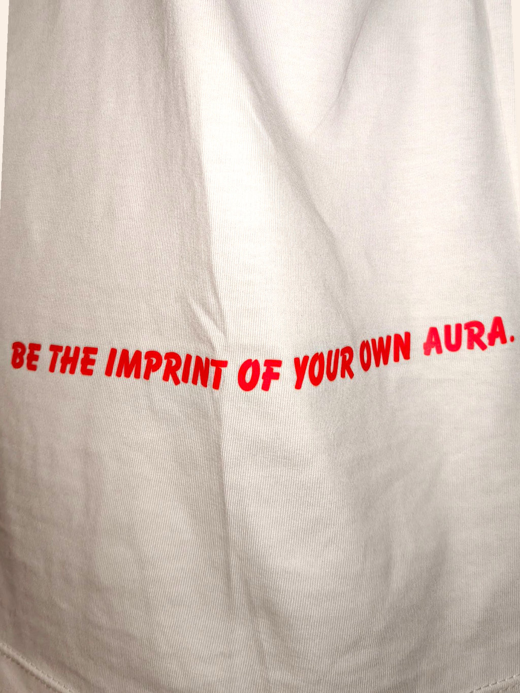 Text 'BE THE IMPRINT OF YOUR OWN AURA.' on a beige background
