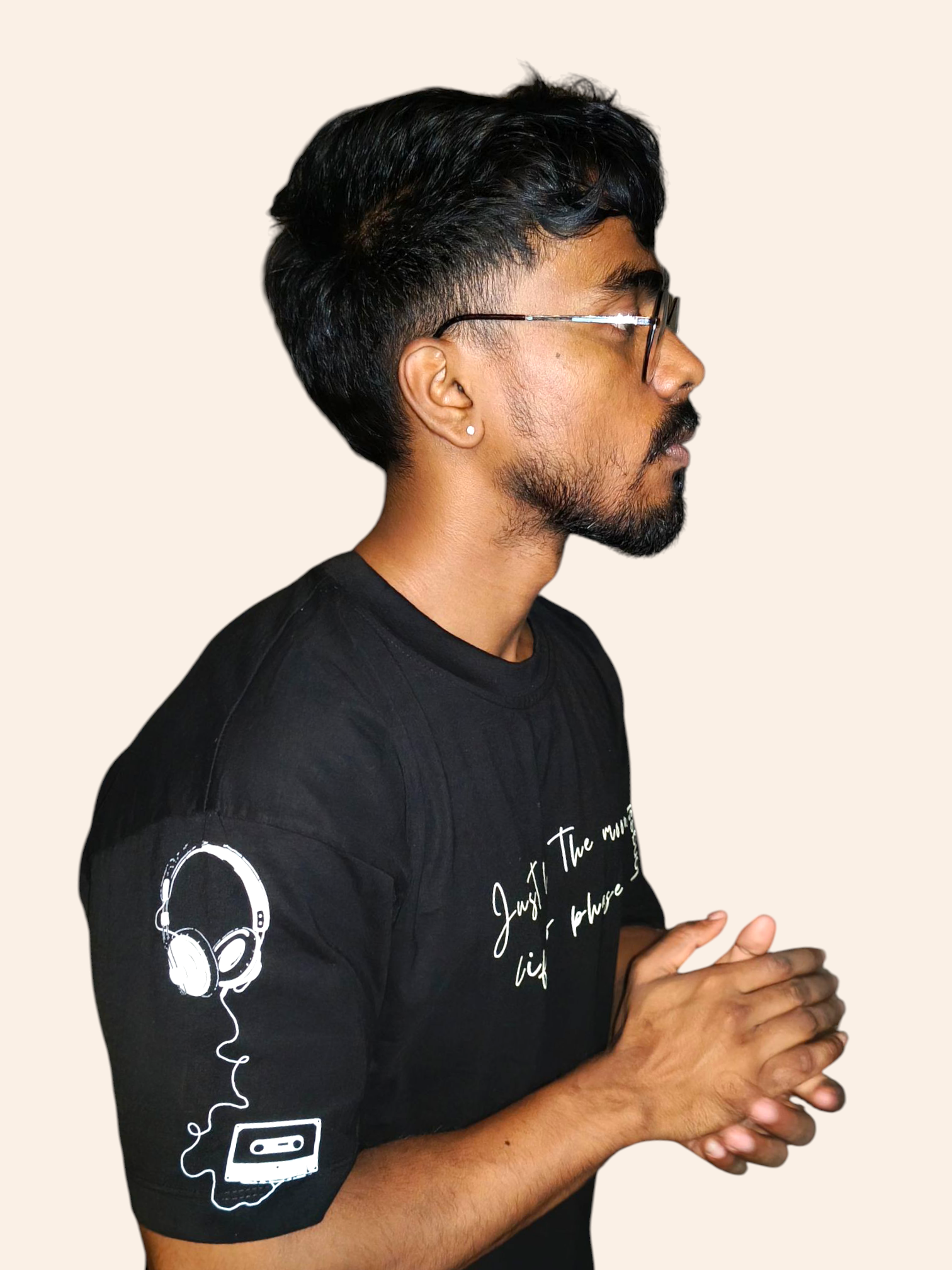 Man wearing a VeerAstra black t-shirt with white graphics and text on a beige background