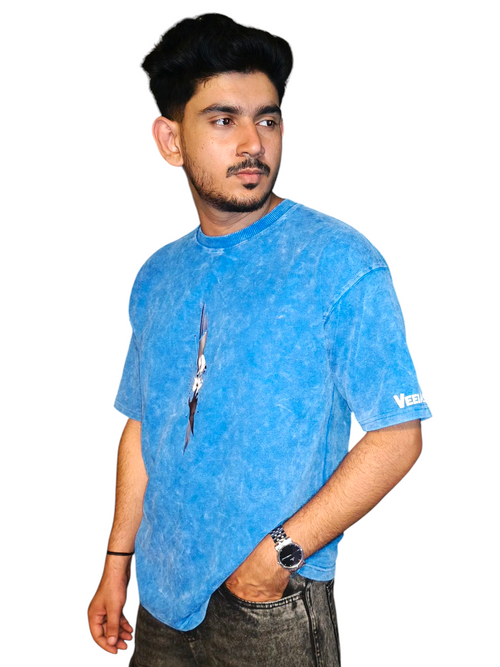 Man wearing a VeerAstra blue Acid wash t-shirt with a brand logo on a white background