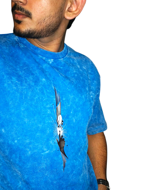 Person wearing a VeerAstra blue Acid  Wash t-shirt with a graphic design on a white background