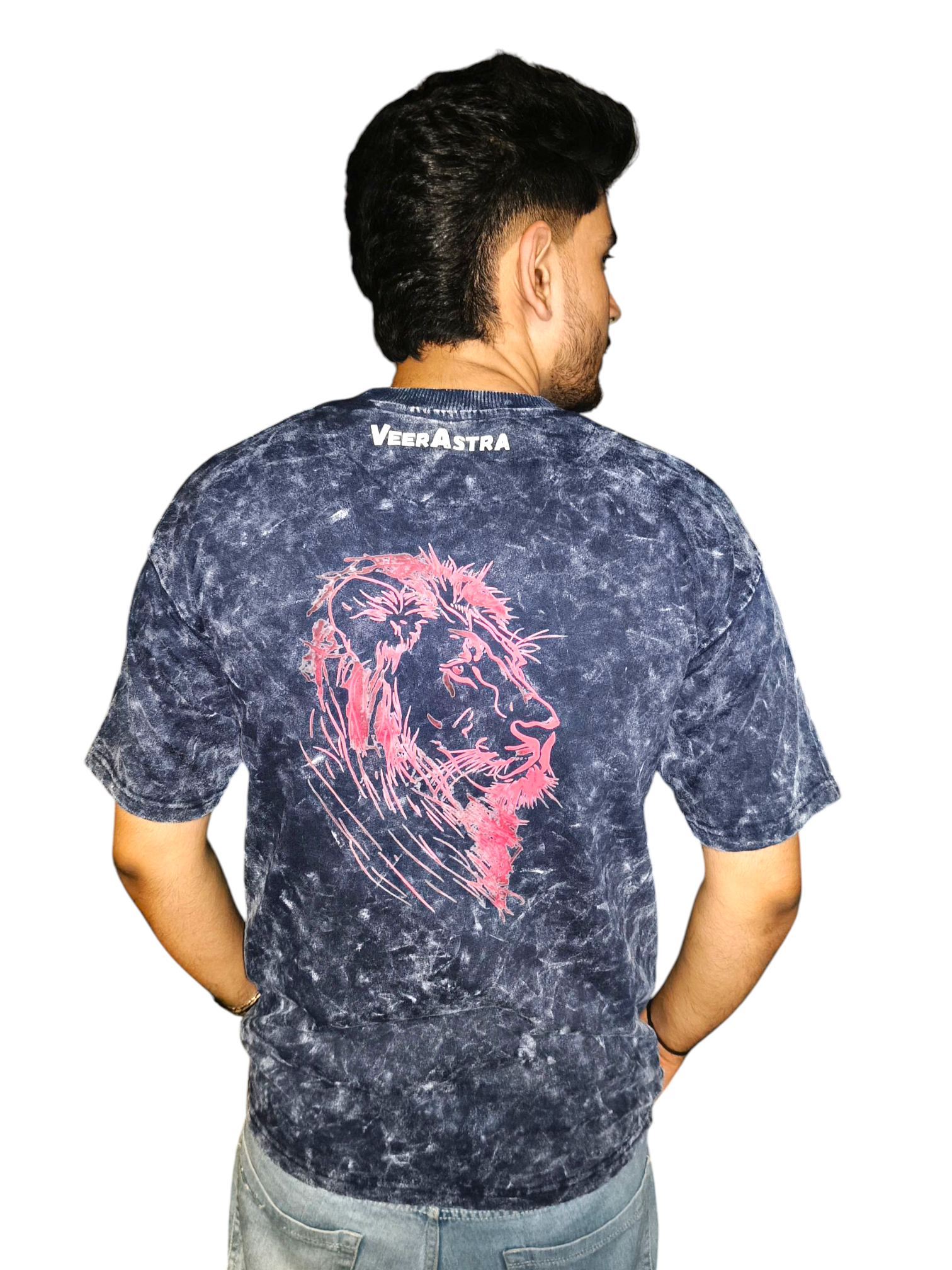 Person wearing a VeerAstra blue acid wash t-shirt with a pink lion design on the back, standing against a white background.