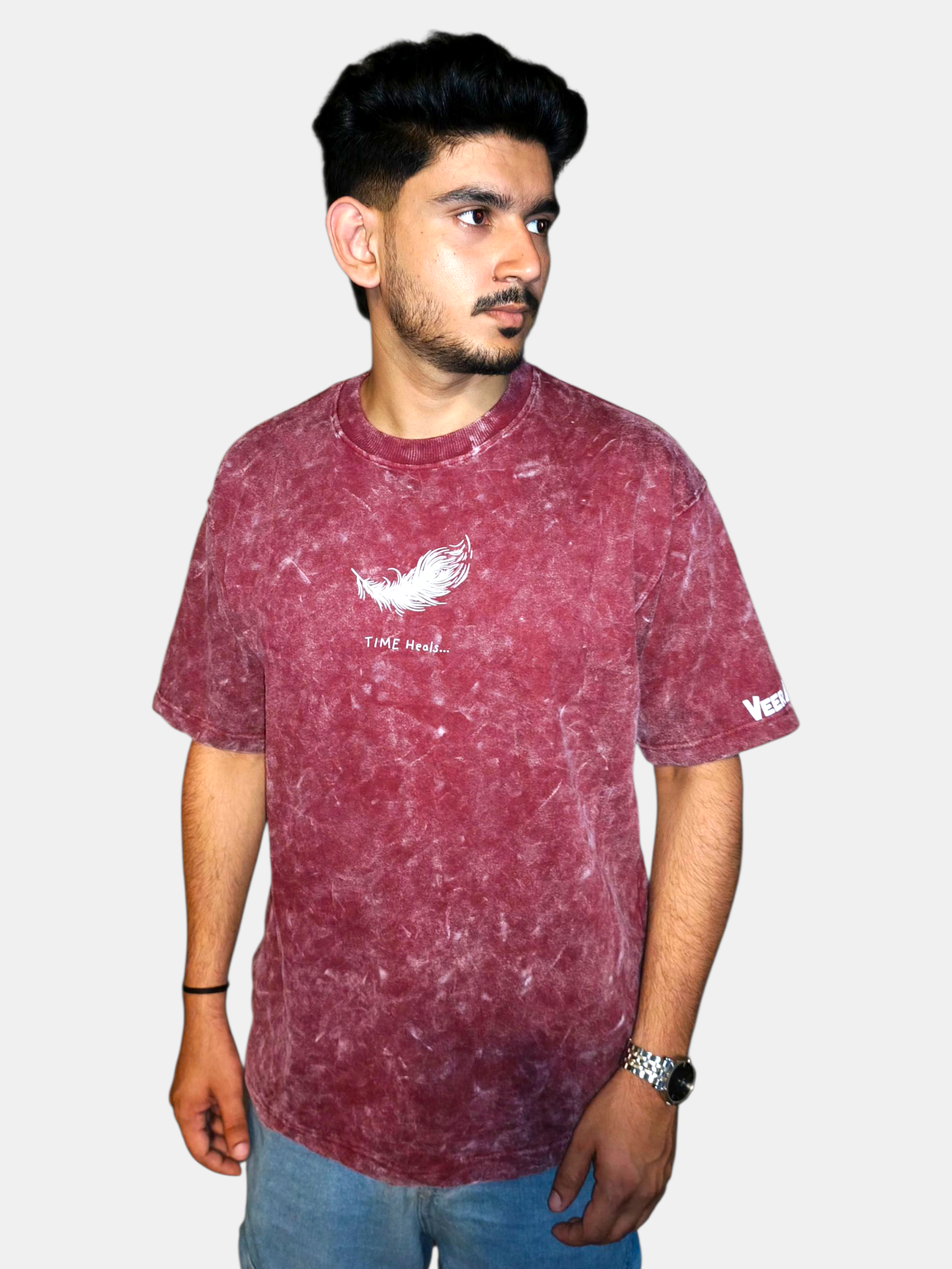 Man wearing a VeerAstra Burgundy acid wash t-shirt with branding on a plain background