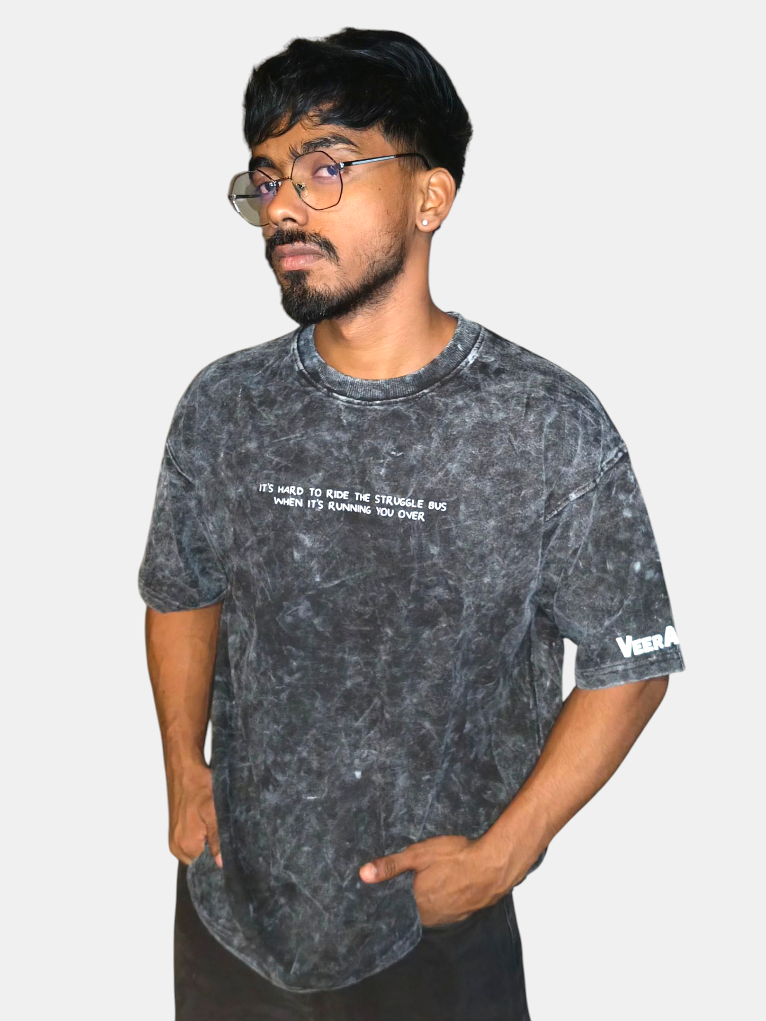 Man wearing a VeerAstra black acid-wash t-shirt with text and branding on a plain background