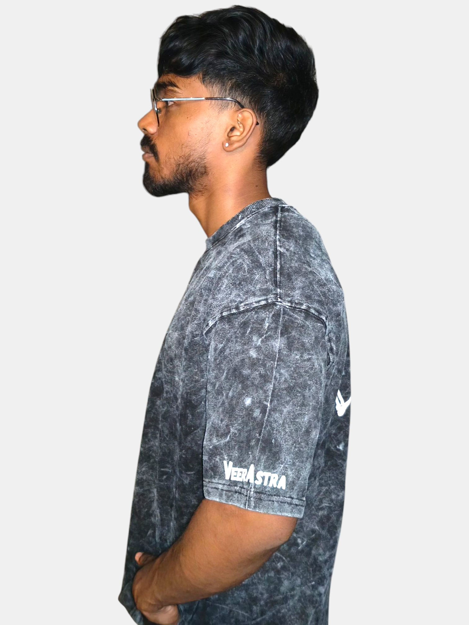 Person wearing a VeerAstra black acid-wash shirt with a brand logo on a white background